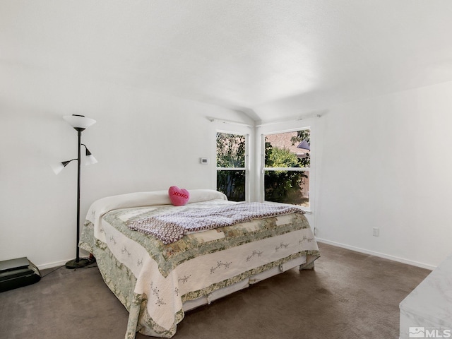 carpeted bedroom with lofted ceiling and baseboards