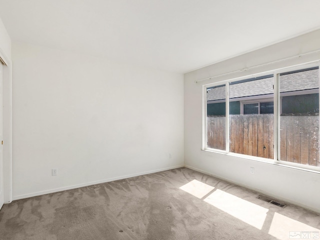 unfurnished room with visible vents, baseboards, and carpet