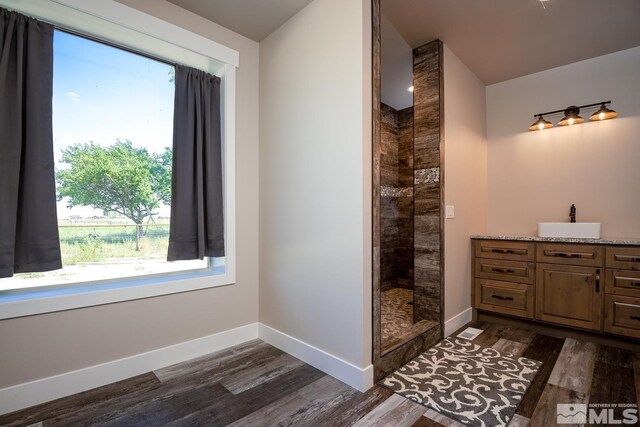 bathroom featuring vanity, tiled shower, and hardwood / wood-style flooring