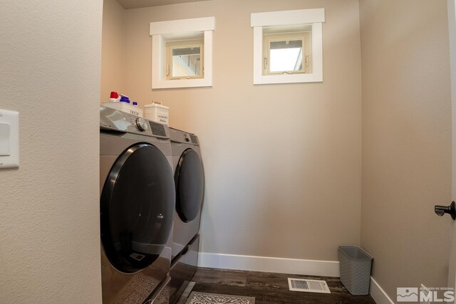 laundry area with washing machine and clothes dryer and dark hardwood / wood-style flooring