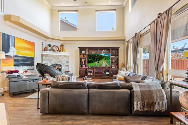 living room featuring crown molding, a brick fireplace, and wood-type flooring