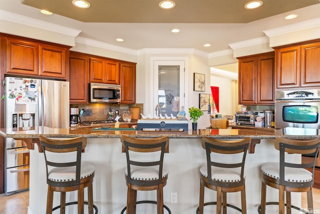 kitchen with stainless steel appliances, a kitchen breakfast bar, and decorative backsplash