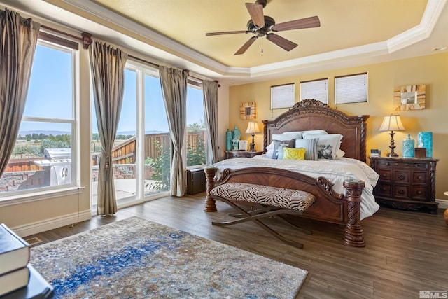 bedroom featuring crown molding, ceiling fan, dark hardwood / wood-style floors, a tray ceiling, and access to outside