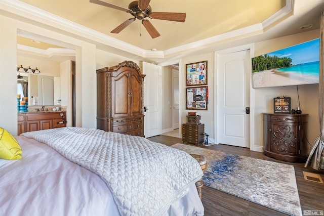 bedroom with a raised ceiling, crown molding, and dark hardwood / wood-style flooring