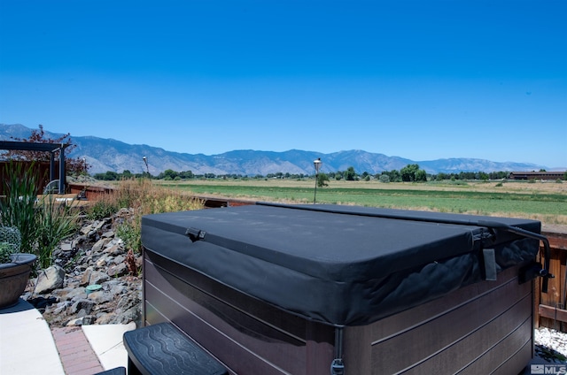 view of yard with a hot tub, a mountain view, and a rural view