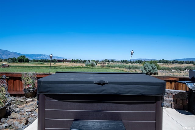 view of yard featuring a hot tub, a mountain view, and a rural view