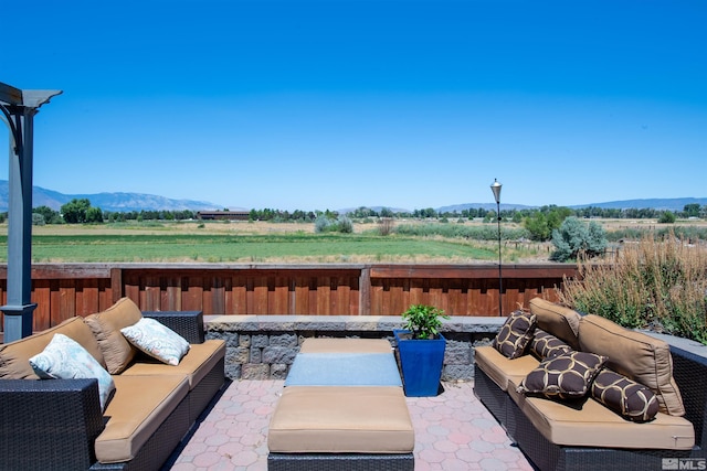 view of patio / terrace featuring an outdoor living space, a mountain view, and a rural view