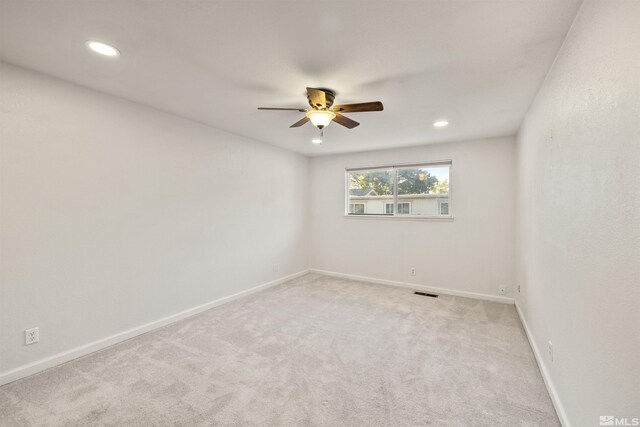 bedroom with light carpet, a barn door, and ceiling fan