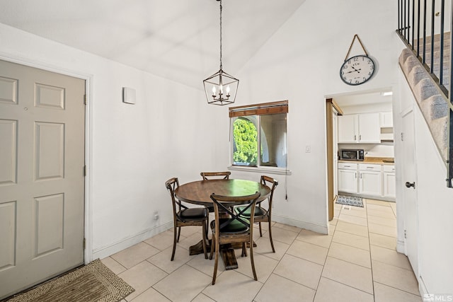 dining space featuring an inviting chandelier, light tile patterned floors, and high vaulted ceiling