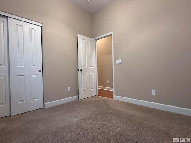 unfurnished bedroom with a towering ceiling, carpet, and a closet