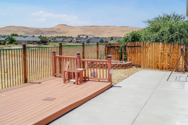 wooden terrace with a mountain view and a patio