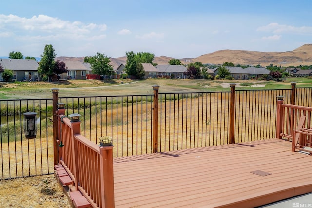 wooden deck with a mountain view and a yard