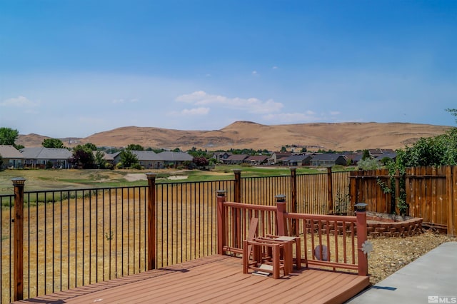 wooden terrace with a mountain view and a yard