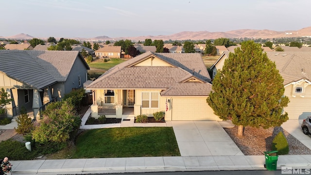 view of front of home featuring a garage, covered porch, and a mountain view