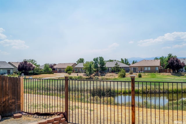 view of gate featuring a water view and a yard