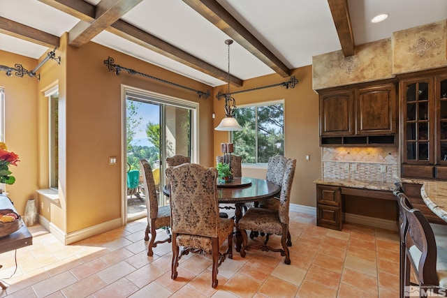 tiled dining space featuring beamed ceiling