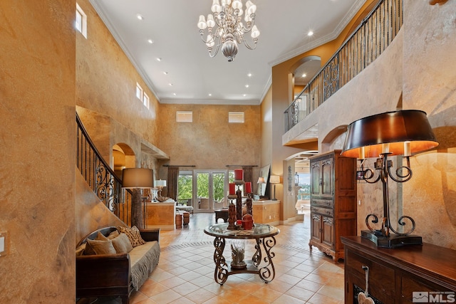 living room featuring light tile patterned flooring, an inviting chandelier, crown molding, and a towering ceiling