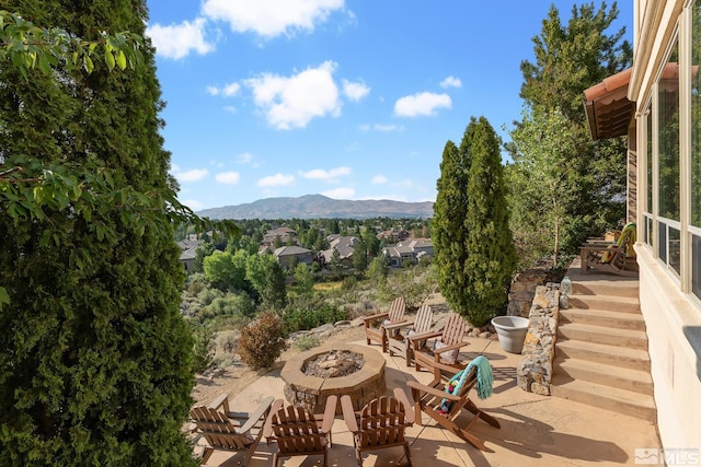 view of patio / terrace with a mountain view and an outdoor fire pit