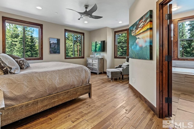 bedroom featuring multiple windows, light hardwood / wood-style flooring, and ceiling fan