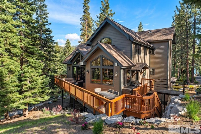 back of house featuring a wooden deck