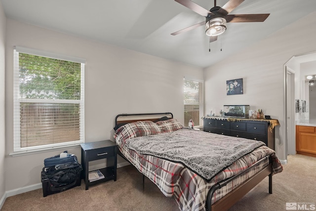 carpeted bedroom featuring vaulted ceiling, ensuite bathroom, and ceiling fan