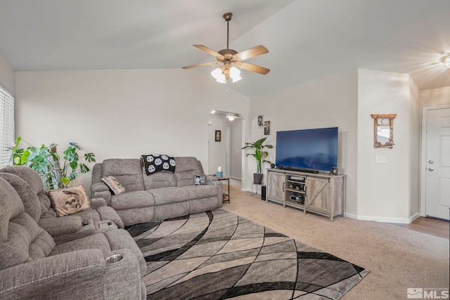 carpeted living room with ceiling fan and vaulted ceiling