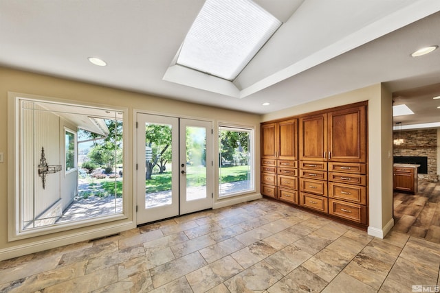 doorway with light tile patterned flooring, lofted ceiling, french doors, and a large fireplace