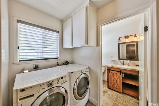 washroom featuring light tile patterned flooring, independent washer and dryer, cabinets, and sink