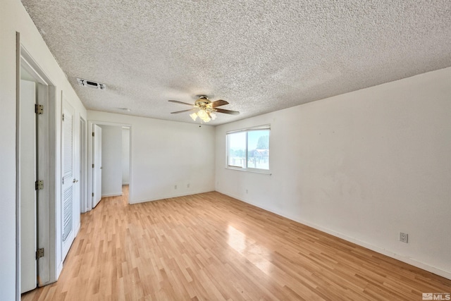 unfurnished bedroom featuring a textured ceiling, ceiling fan, and light wood-type flooring