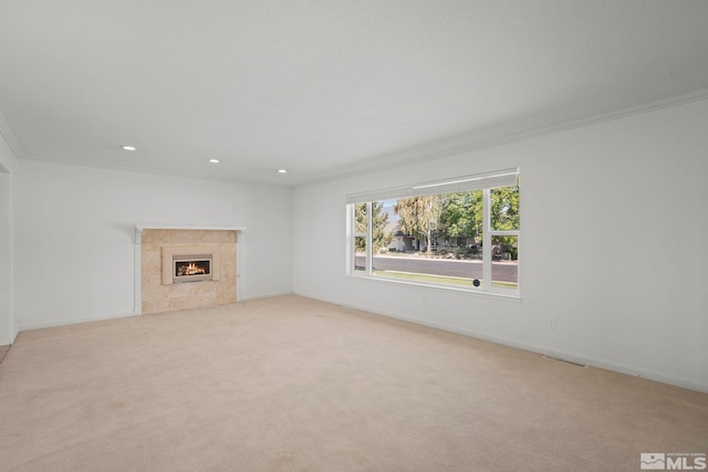 unfurnished living room with a fireplace, light carpet, and ornamental molding