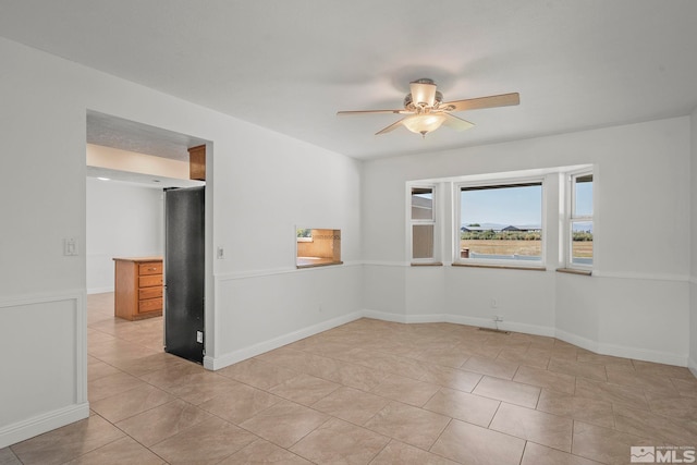 empty room featuring ceiling fan and light tile patterned flooring