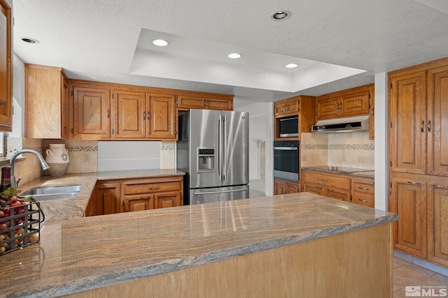 kitchen featuring tasteful backsplash, stainless steel appliances, kitchen peninsula, sink, and stone countertops