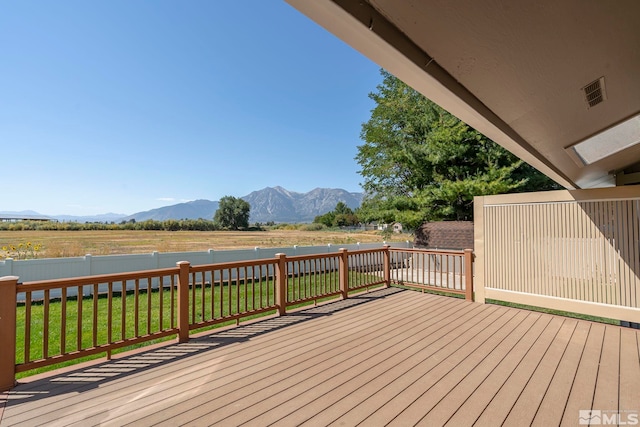 deck with a lawn and a mountain view