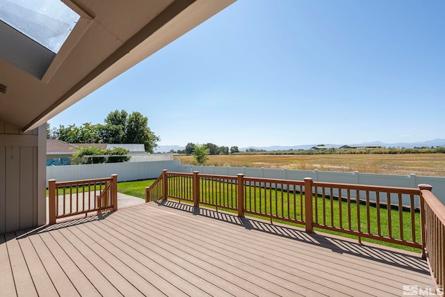 wooden terrace featuring a yard and a rural view