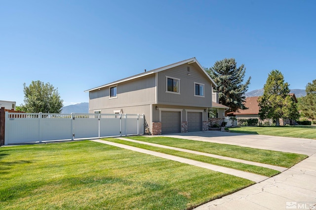 exterior space with a mountain view, a garage, and a front lawn