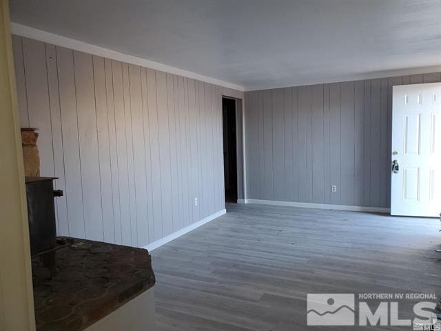 unfurnished room with ornamental molding, wood finished floors, and baseboards