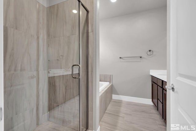 bathroom with vanity and separate shower and tub