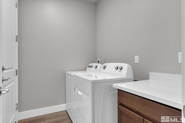 laundry room with cabinets, independent washer and dryer, and light wood-type flooring