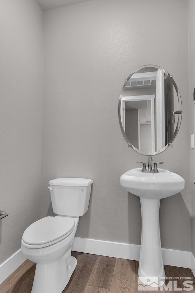 bathroom with wood-type flooring and toilet