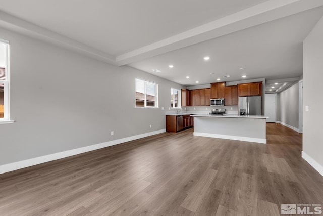 unfurnished living room featuring sink and light wood-type flooring