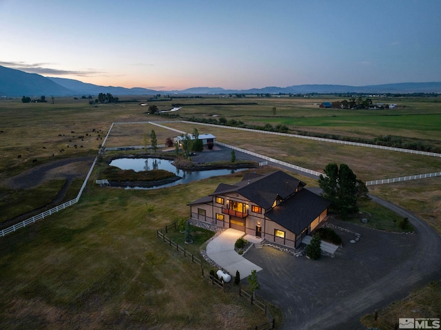 aerial view at dusk featuring a mountain view and a rural view