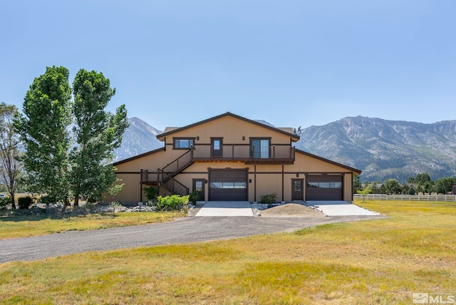 view of front property with a mountain view, a garage, and a front lawn