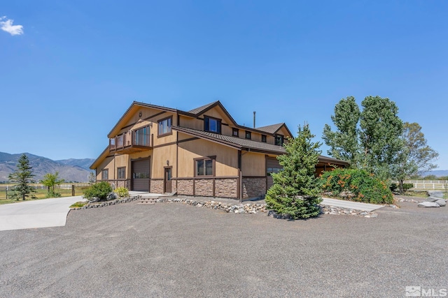 view of front of home with a balcony and a mountain view