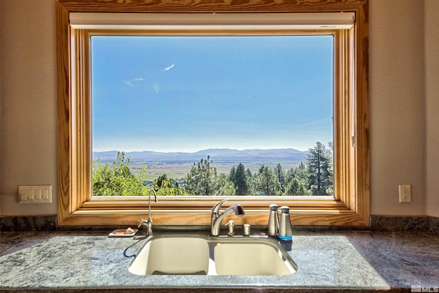 details featuring a mountain view, sink, and light stone counters