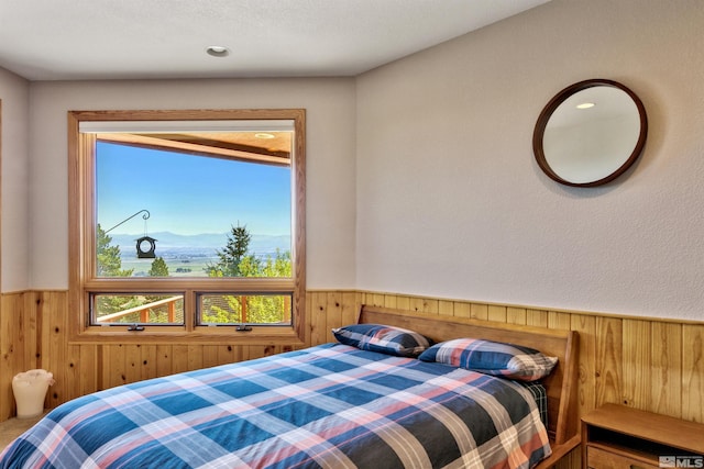 bedroom with a mountain view and wood walls