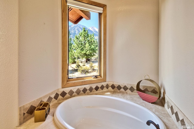 bathroom with a tub to relax in and a mountain view