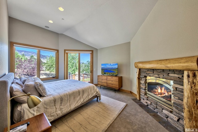 carpeted bedroom with access to exterior, vaulted ceiling, and a fireplace