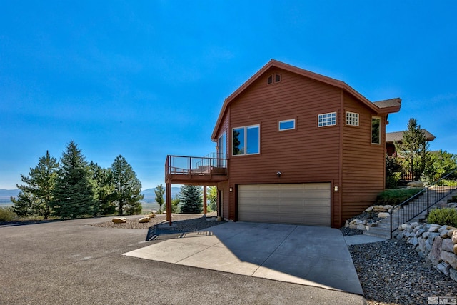 view of home's exterior featuring a garage and a deck with mountain view