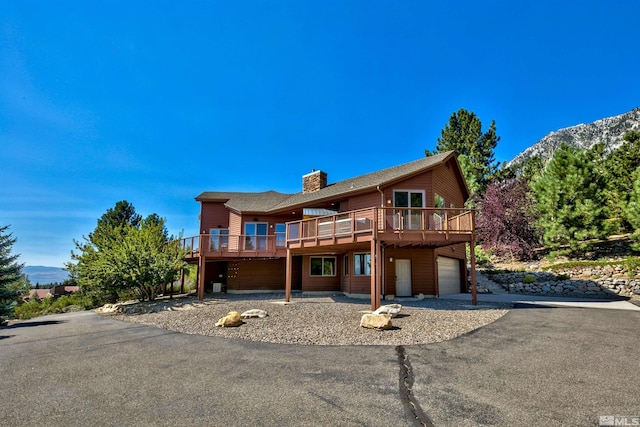 view of front property featuring a garage and a deck with mountain view