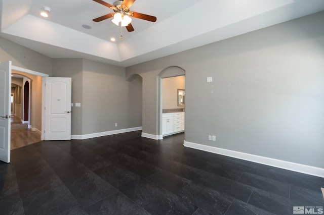 unfurnished room featuring ceiling fan and a tray ceiling